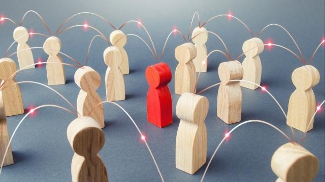 Image of plain wooden people to depict - People connected people by lines. Cooperation and collaboration, news gossip spread. Teamwork. Society concept. Social science relationships. Marketing, dissemination of trends and information