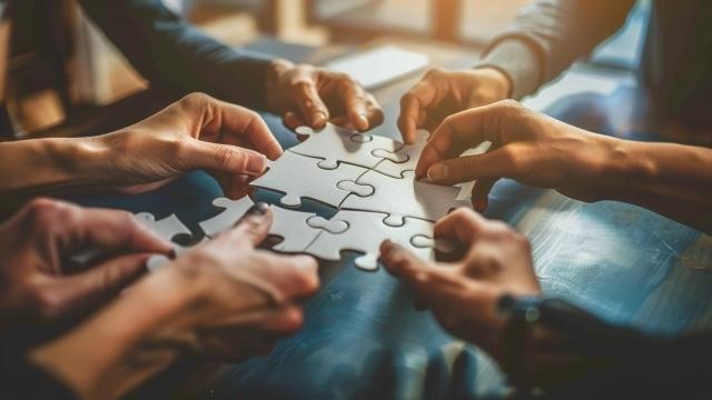 An image of A puzzle being assembled by a team each piece representing a different aspect of their business vision and goals coming together